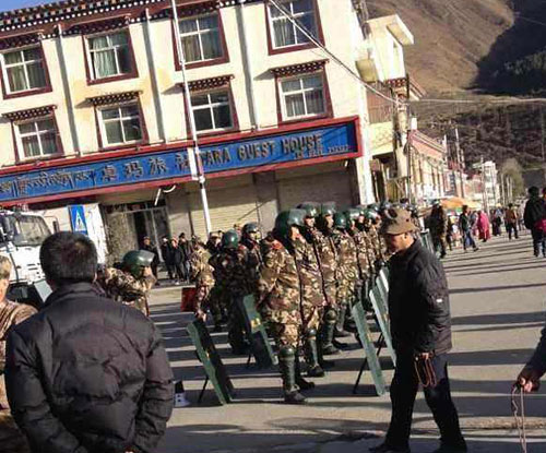 Armed police in riot gear block a road near the site of the self-immolation.